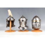 Three miniature desk top helmet ornaments; plumed Roman helmet and two knights visor helmets and