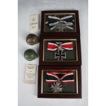 Two German Herr miniature helmets by Tiger Collectables, M35 series and three German replica medals;