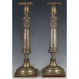 A pair of 19th Century candlesticks, repoussé decoration to drips, leaf carving and decoration to
