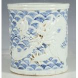 A Chinese brush pot, blue wave glaze, applied cream dragon and leaping fish, impress mark to base,