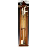 An Admiral Fitzroy barometer, 19th Century oak case with fleur de lys finial, storm glass and