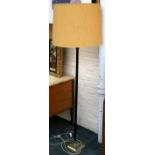 A standard lamp, brass stepped base with linen-fold decoration, black Corinthian column stem brass