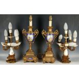 A pair of French gilt metal table lamps, painted with 18th Century women in an oval cartouche,