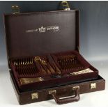 A brown leather cased Bestecke & Solingen canteen of cutlery for twelve, having gold plated handles.