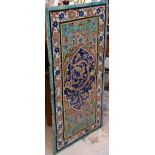 An Iznik tiled rectangular panel with central cartouche, decorated with scrolling flower and