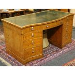 A 19th Century serpentine kneehole desk in satinwood, with boxwood inlay and green leather writing