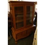 An oak china display cabinet with two glazed doors, enclosing shelves, on base with two drawers,