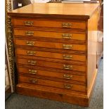 An Edwardian oak and satinwood plan chest of seven long drawers, raised on a plinth base.