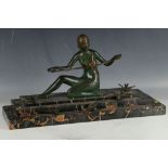 An Art Deco bronze of a seated maiden surrounded by doves, on a variegated marble base.