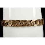 A 9ct yellow gold flat curb link bracelet with all-over tree bark textured finish.