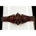 A late Victorian silver and garnet set cluster hinged bracelet.