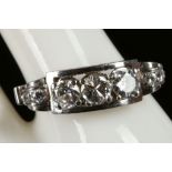 A continental 18ct white gold and diamond ring, the three central claw set round cut stones