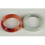 Two Chinese jade bracelets, red and green. (2)