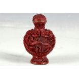 A Chinese red snuff bottle, globular, landscape and figure decoration, brass character stamp to