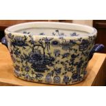 An oval section blue and white decorated foot bath with domestic everyday Chinese scenes.