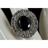 An 18ct white gold, large ring with a 7.2 carat central black diamond surrounded by 4.31 carats of