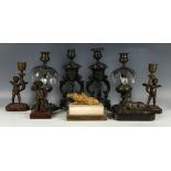 A small collection of collectable antique bronze items comprising a pair of cupid candlesticks, a