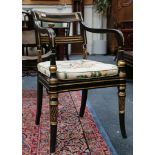 A pair of Regency black painted and panel gilt bar backed elbow chairs together with another with