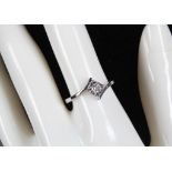 An 18ct white gold and diamond cross-over solitaire ring (diamond: 0.10ct).