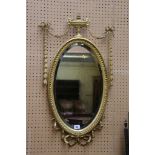 A good Georgian style gilt framed oval levelled mirror with vase and swag crossing and ribbon