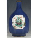 An Asian porcelain bottle form vase, one blue ground having white cartouche decorated with flowers.