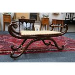 A Regency simulated rosewood and parcel gilt window seat of scrolling 'x' construction with a