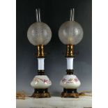 A pair of Victorian porcelain and metal mounted continental table lamps, with glass shades. (2)