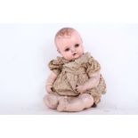 A 1940s German K & W Hartgummi 104 hard plastic character baby doll, with brown glass flirty eyes,