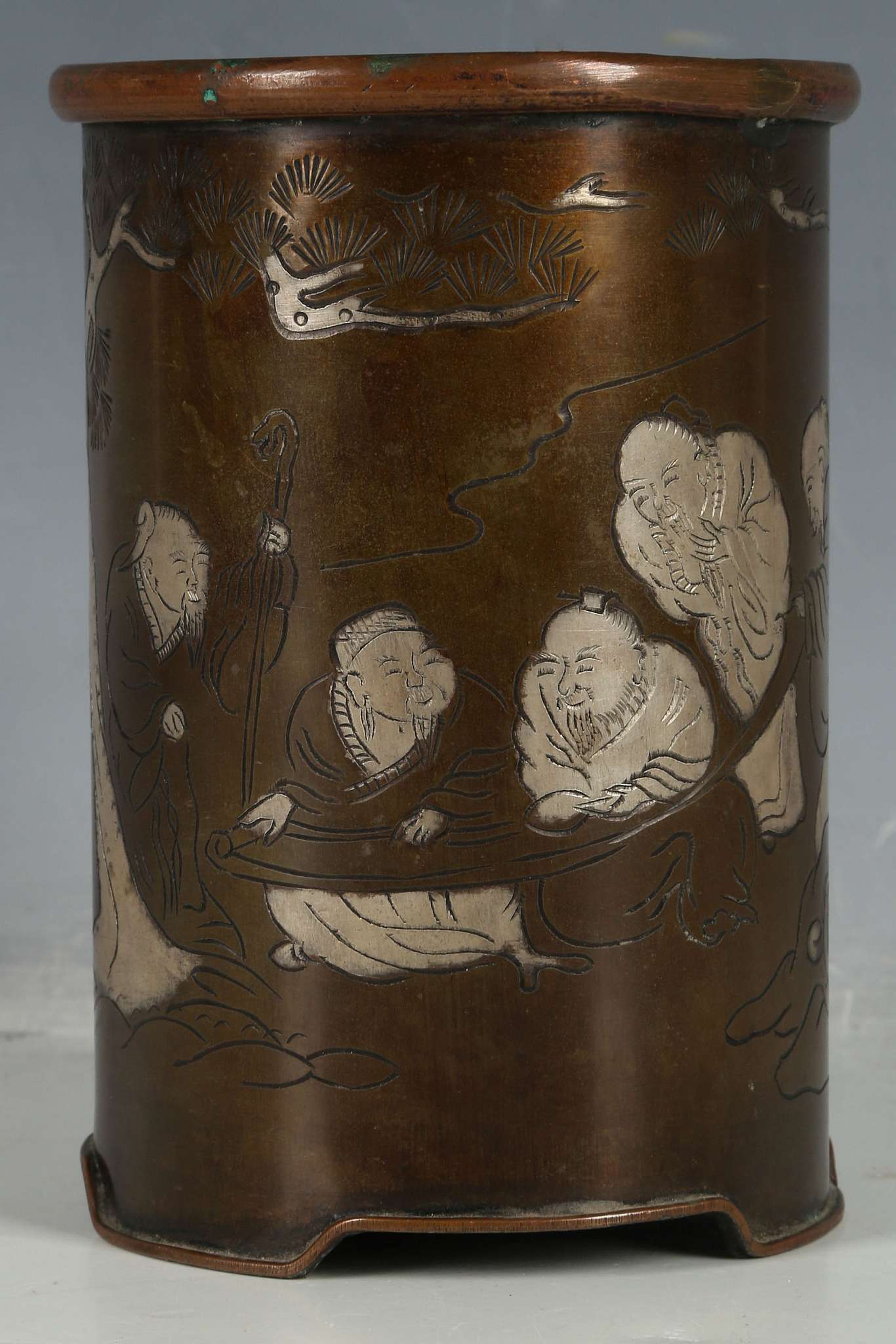 A Chinese bronzed brush pot, copper rim, elders examining scroll, inscription and signature to edge,