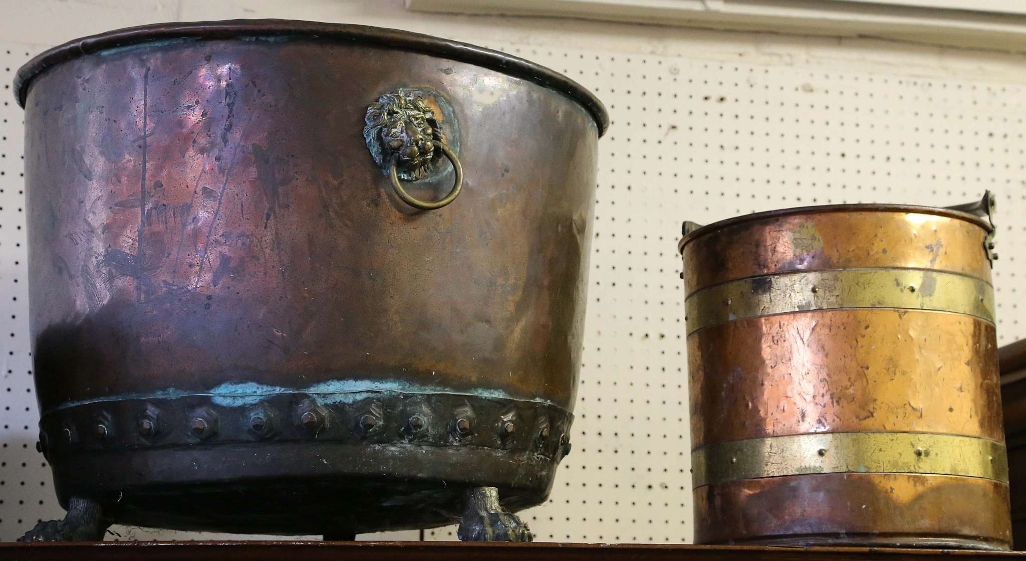 A large copper bucket on brass paw feet, a small coopered bucket with swing handle, and a mahogany