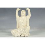 A Chinese blanc de Chine study of Buddha with arms aloft, impressed stamps to rear, 14cm high.