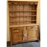 A Victorian pine farmhouse high dresser, having four shelves above two cupboards and two drawers,
