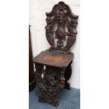 A pair of 18th Century style hall chairs, scallop and face of the wind flanked by caryatid semi-nude