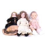 Two 1900s bisque head girl dolls and an Effanbee composition character girl doll (AF). (3)