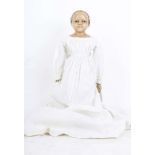 An 1850s wax over composition child doll, English, with provenance and extra clothing, the doll