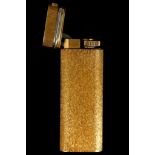 A gold plated Cartier pocket lighter, with textured finish, gold tri-colour collar and three stone