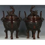 A pair of Chinese early 20th Century bronze censers, dragon finials, loop handles, with temple