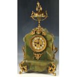 A green onyx mantel clock, brass finial, floral embellishments and face, acanthus form feet and