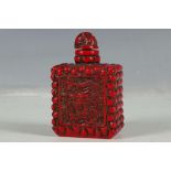 A Chinese snuff bottle, red brick form, studies of dragons to panels, 7.5cm high.