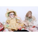 A Kestner all bisque child doll with a full family trousseau and two further all bisque dolls, the