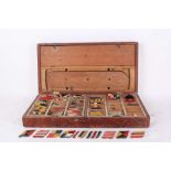 A 1900s boxed game of boating flags, a wooden boat with hand painted wooden flags and three flag