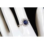 An 18ct white gold, sapphire and diamond set cluster ring (sapphire 0.83ct, diamond 0.06ct).