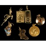 A miscellaneous collection of hallmarked gold charms and pendants to include an eagle claw holding a