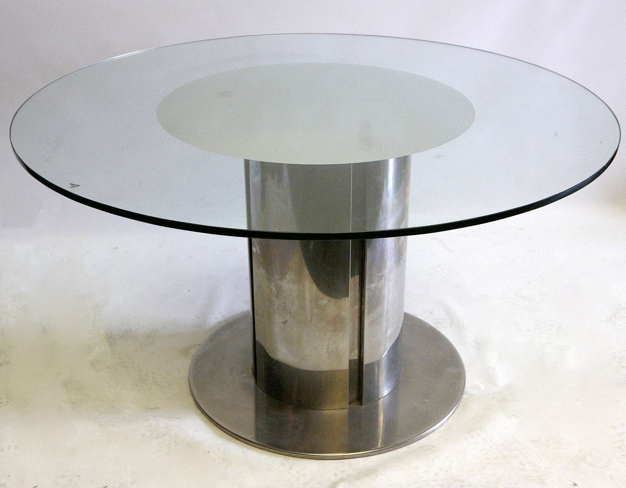 A 1970's Willy Rizzo style dining table, with circular glass top with mirrored centre, on brushed