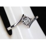 An 18ct white gold and diamond cross-over solitaire ring (diamond: 0.10ct).