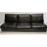 A 1970's black leather sofa bed, 3 seater with removable cushions revealing a pullout bed, chrome