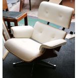 A Charles Eames style cream leather lounge chair, with cherrywood shells