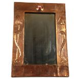 An Art Nouveau mirror with copper embossed frame and Ruskin high fired ceramic cabochon, possibly