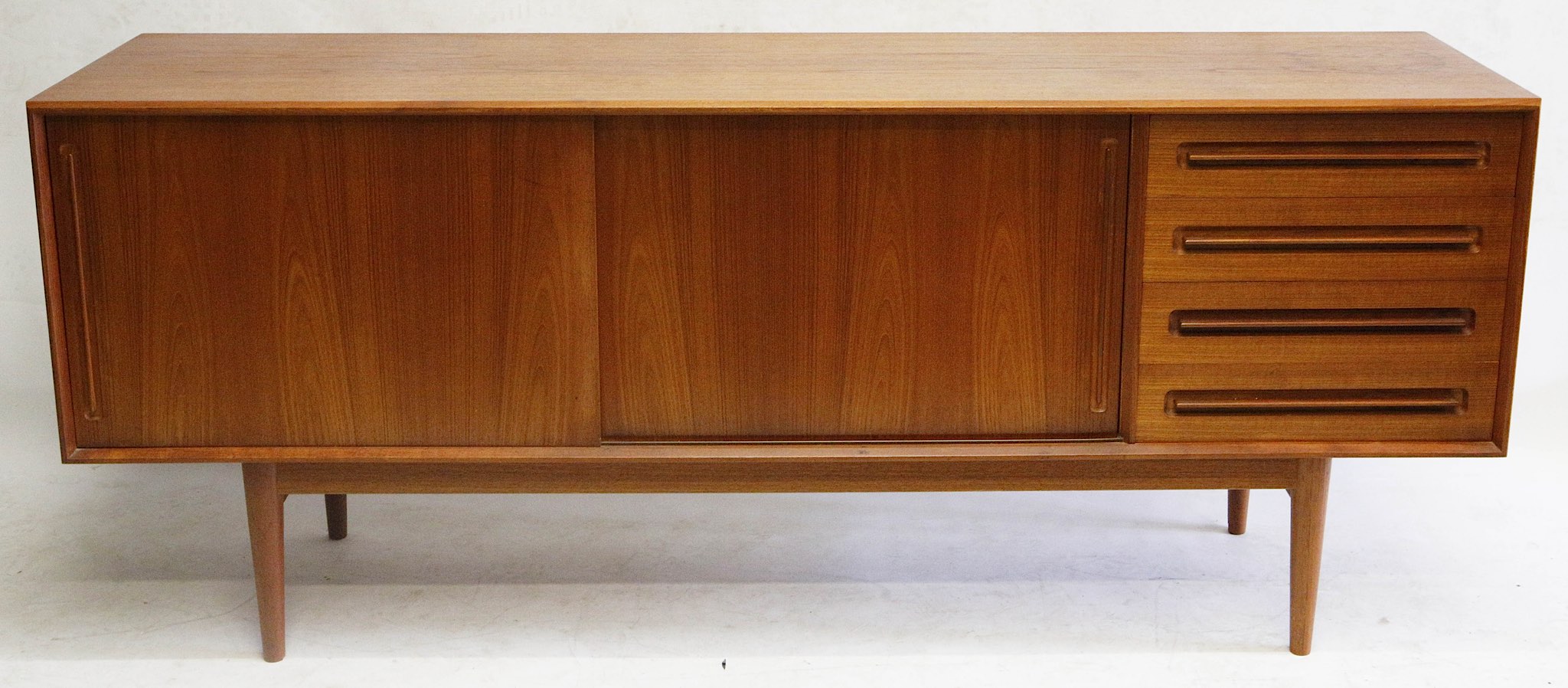 A 1960s Danish teak sideboard, double cupboard with sliding doors, four drawers, stamped B&N Made In