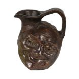 A Martin Brother's stoneware grotesque double-sided face jug, circa 1900, with dark brown and